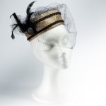 Vista frontal del tocado estilo casquete, pasamanería, plumas y tul vintage
